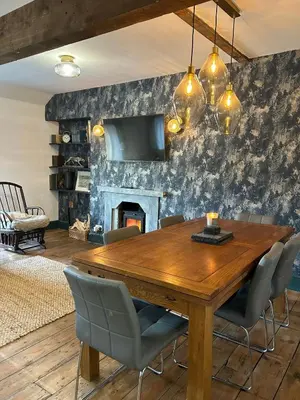 a dining room with a wooden table and a fireplace at Dolgellau Grand Heights Apt in Dolgellau