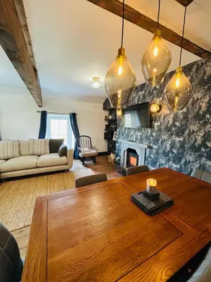 a living room with a wooden table and a fireplace at Dolgellau Grand Heights Apt in Dolgellau