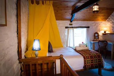a bedroom with a bed with a yellow tent at Tan Y Bryn in Llanrhystyd