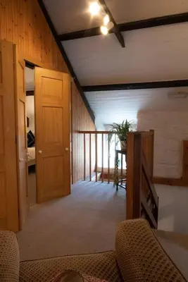 a living room with a couch and a wooden door at Yr Hen Efail - Old Smithy in Tregaron