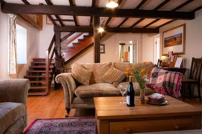 a living room with a couch and a table at Yr Hen Efail - Old Smithy in Tregaron