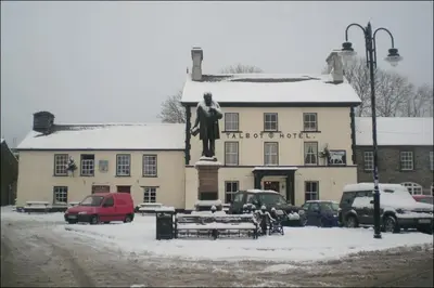 a building with a statue in front of it in the snow at Yr Hen Efail - Old Smithy in Tregaron