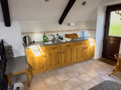 a kitchen with wooden cabinets and a sink at Crogal Stable in New Quay