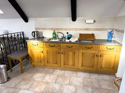a kitchen with wooden cabinets and a sink at Crogal Stable in New Quay