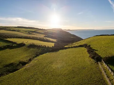 an aerial view of a field with the ocean in the background at Crogal Stable in New Quay