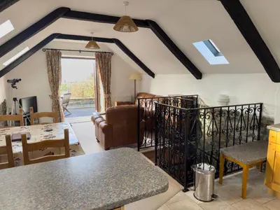a kitchen and living room with a table and chairs at Crogal Stable in New Quay