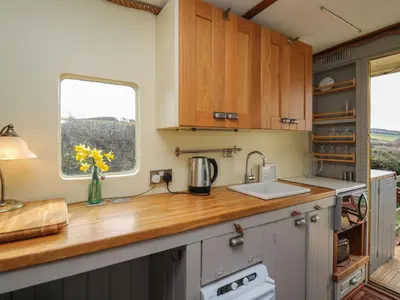 a kitchen with a counter with a sink and a window at Sea the Stars in New Quay