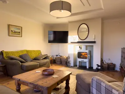 a living room with a couch and a table and a fireplace at Crogal Farmhouse in New Quay