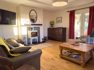 a living room with a couch and a table and a fireplace at Crogal Farmhouse in New Quay