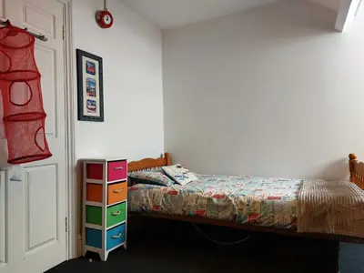 a bedroom with a bed and a dresser at Trem Y Mor - Edge of the Sea in Tywyn