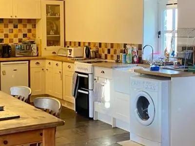 a kitchen with a washer and a dishwasher at Ysgubor y Tanybryn The barn with a view and a spa. in Tregaron