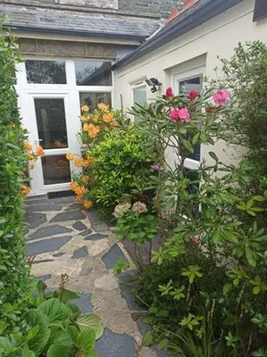 a garden with flowers in front of a house at Penbryn Mynach Holiday Cottage in Barmouth