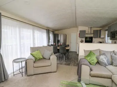 a living room with two couches and a kitchen at 43 The Deri in New Quay