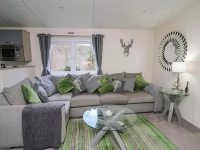a living room with a couch and a glass table at 43 The Deri in New Quay