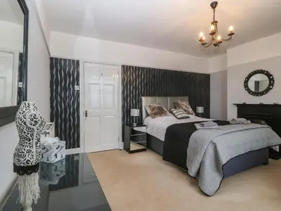 a bedroom with a bed and a chandelier at Morolwg in Barmouth