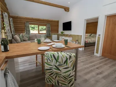 a dining room with a table and a couch at Redwood Lodge in Ellesmere