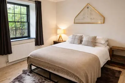 a bedroom with a large bed and two windows at Glandwr Lodge, 3 bed in Barmouth, Wales in Barmouth