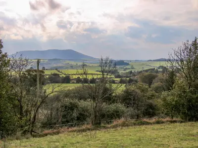a view of a field with a mountain in the distance at The Chicken Coop in Shrewsbury