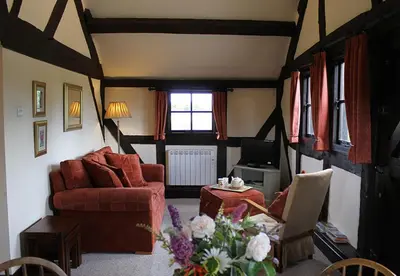 a living room with a red couch and a tv at Cider Press in Hereford