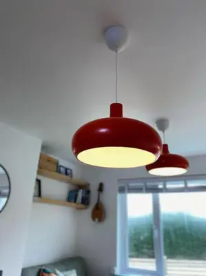 two lights hanging from a ceiling in a room at Bungalow, mountain and sea views parking in Aberdyfi