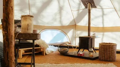 a room with a tent with a wood stove at Cuddfan Bach (The Little Hideaway) at Camp Plas in Welshpool