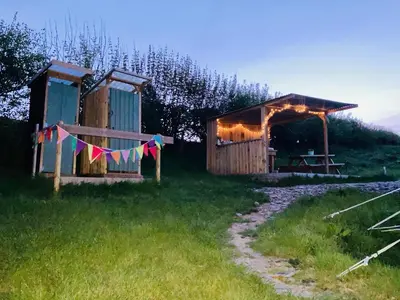 a cabin with a string of flags in a field at Luxury Stargazing Glamping - Seren Aur with Hot Tub in Llanidloes