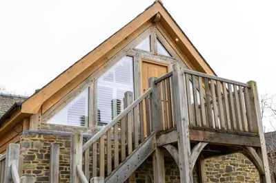 a house with a wooden deck on top of it at Plas Robin in Montgomery