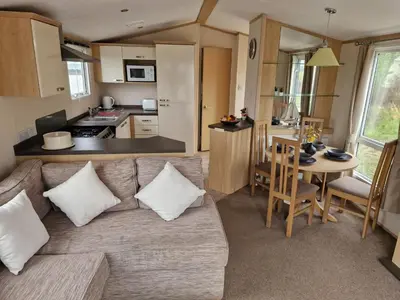 a living room with a couch and a kitchen at Harries Lodge 2 Aberaeron in Aberaeron
