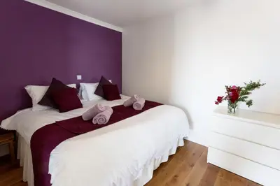 a bedroom with a white bed with towels on it at Seabreeze Aberaeron in Aberaeron