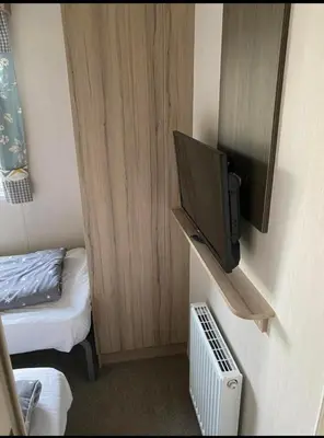 a small room with a tv on a wall at Experience Coastal Bliss in Our Modern 2019 Sea Viev 2 Bedroom static caravan at Clarach Bay Holiday Village! in Aberystwyth