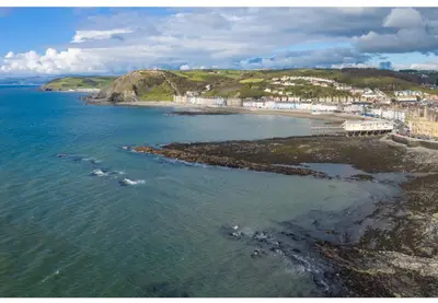 an aerial view of a beach and the ocean at Experience Coastal Bliss in Our Modern 2019 Sea Viev 2 Bedroom static caravan at Clarach Bay Holiday Village! in Aberystwyth