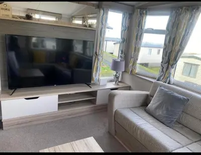 a living room with a large flat screen tv at Experience Coastal Bliss in Our Modern 2019 Sea Viev 2 Bedroom static caravan at Clarach Bay Holiday Village! in Aberystwyth