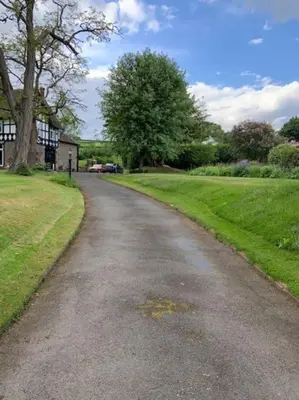 a road leading to a house with a tree at Beautiful converted Coach house for two in Hoptonheath