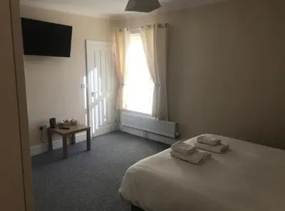 a bedroom with a bed and a window and a table at Nags Head Pub in Lampeter