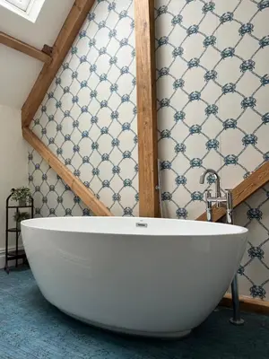 a white tub in a bathroom with a wall at The Pink House in Brecon
