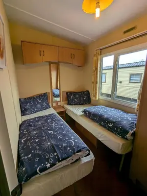 two beds in a small room with a window at The fox den in Rhos-gôch