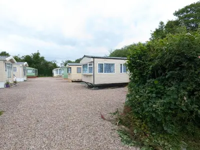 a row of mobile homes parked in a driveway at The fox den in Rhos-gôch