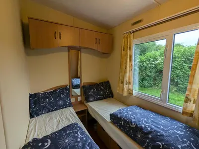 a small room with two beds and a window at The fox den in Rhos-gôch