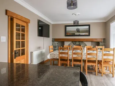 a kitchen and dining room with a table and chairs at Mynydd ar Mor in Barmouth