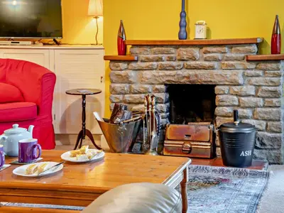 a living room with a stone fireplace and a table at 3 Bed in Brecon oc-93947 in Llanywern