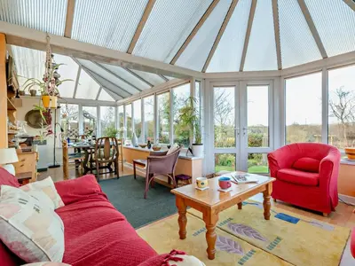 a living room with a red couch and a table at 3 Bed in Brecon oc-93947 in Llanywern
