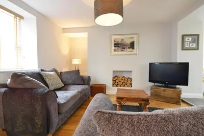 a living room with a couch and a tv at Y Bwthyn Aberaeron in Aberaeron