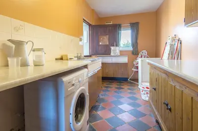 a kitchen with a washer and dryer in it at Brynonnen Llangrannog in Llanllwchaiarn