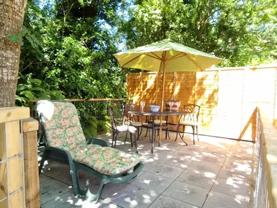 a patio with a table and an umbrella at Arwel Llangrannog in Llanllwchaiarn