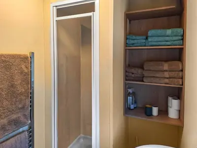 a bathroom with a shower and a mirror and towels at Glen Y Nant in Llanfihangel-nant-Melan