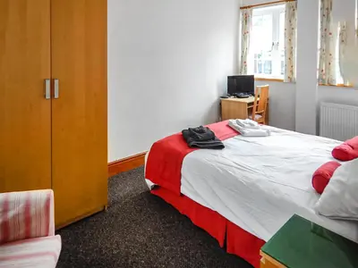 a bedroom with a bed and a desk with a computer at The Annex At Is Y Coed in Welshpool