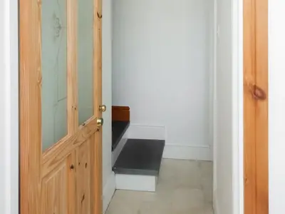 a hallway with a wooden door and a stair case at The Annex At Is Y Coed in Welshpool