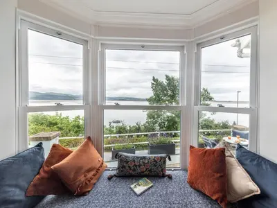 a living room with a couch and large windows at 4 Bed in Aberdovey 94232 in Aberdyfi