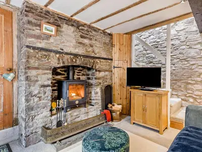 a stone fireplace in a living room with a tv at 2 Bed in Brecon oc-92729 in Brecon