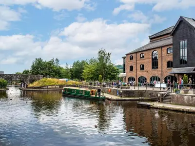 a boat in a river in front of a building at 2 Bed in Brecon oc-92729 in Brecon